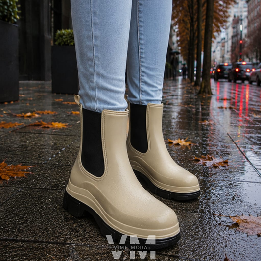 Botín de Agua Mujer Beige usado con jeans sobre una calle mojada