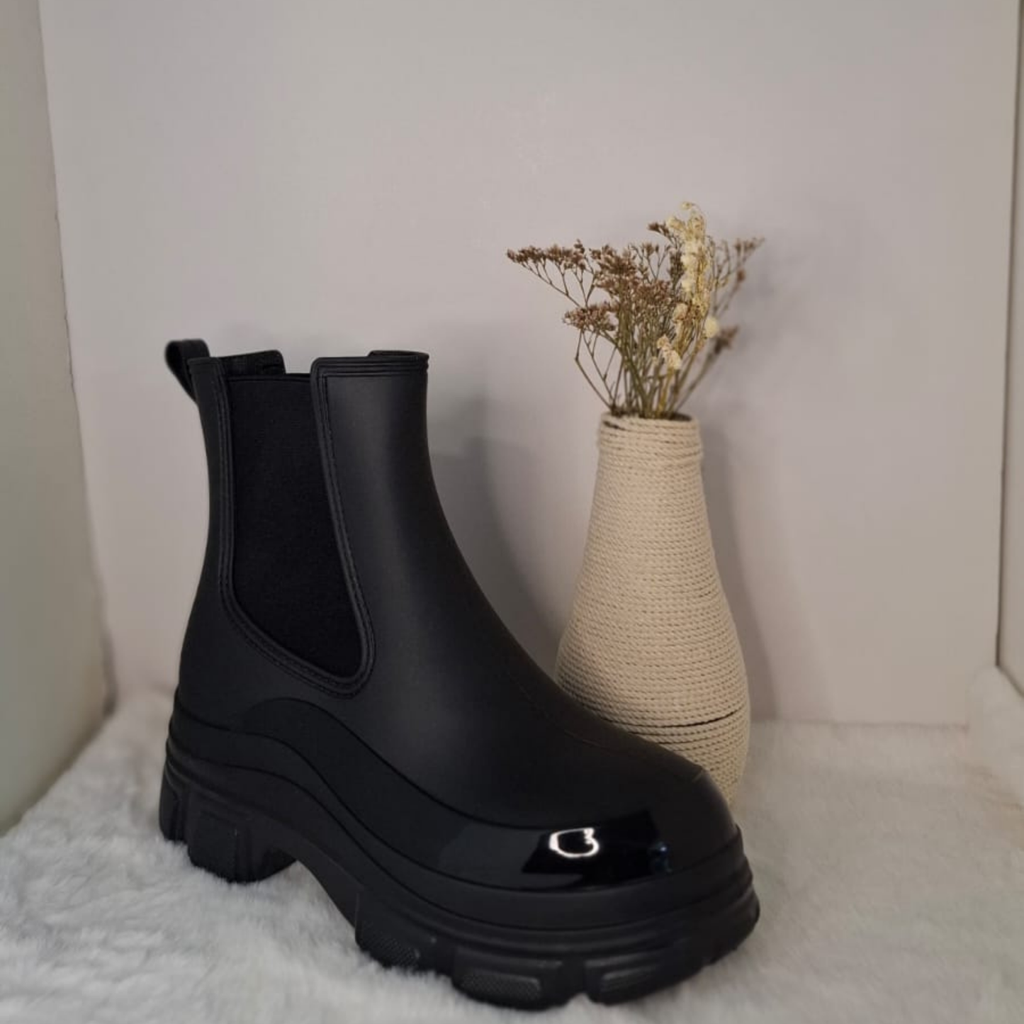 Botín estilo Chelsea de color negro mate para mujer, con suela track de plataforma y detalle de puntera brillante, ideal para lluvia o uso urbano. vime moda chile