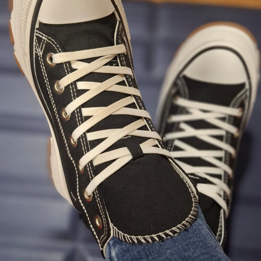 Zapatilla de lona estilo converse en color negro para mujer, con cordones blancos, costuras visibles y una suela de plataforma ancha con base dentada en color caramelo.vime moda chile
