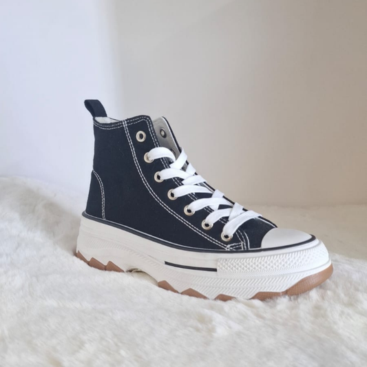 Zapatilla de lona estilo converse en color negro para mujer, con cordones blancos, costuras visibles y una suela de plataforma ancha con base dentada en color caramelo. vime moda chile