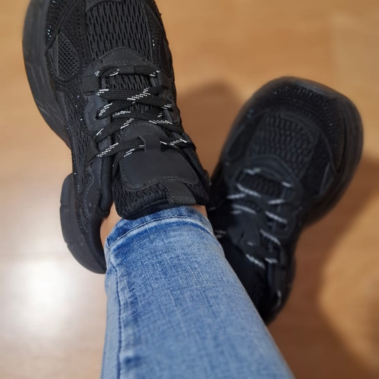 Zapatilla urbana estilo chunky para mujer en color negro, con detalles de pequeños brillos (strass) en la superficie, malla transpirable y una plataforma robusta totalmente negra.vime moda chile