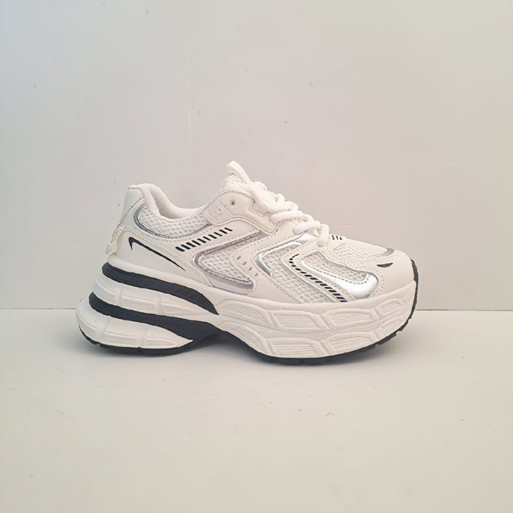 Zapatilla perla titanio estilo chunky para mujer en color blanco con detalles en negro y gris, malla transpirable y una plataforma robusta de gran altura.vime moda chile