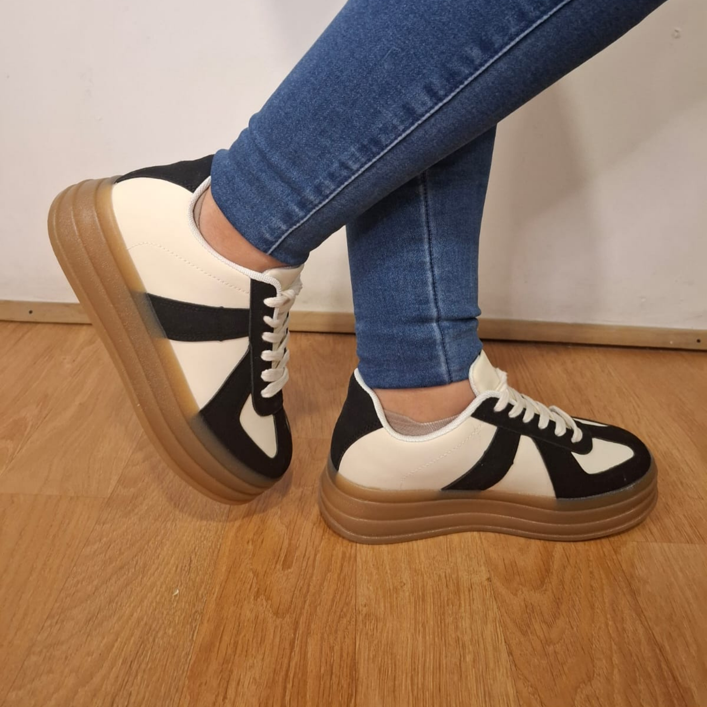 Zapatilla urbana para mujer en color crema con refuerzos y detalles en gamuza negra, cordones blancos y una suela de plataforma ancha en goma color café.vime moda chile