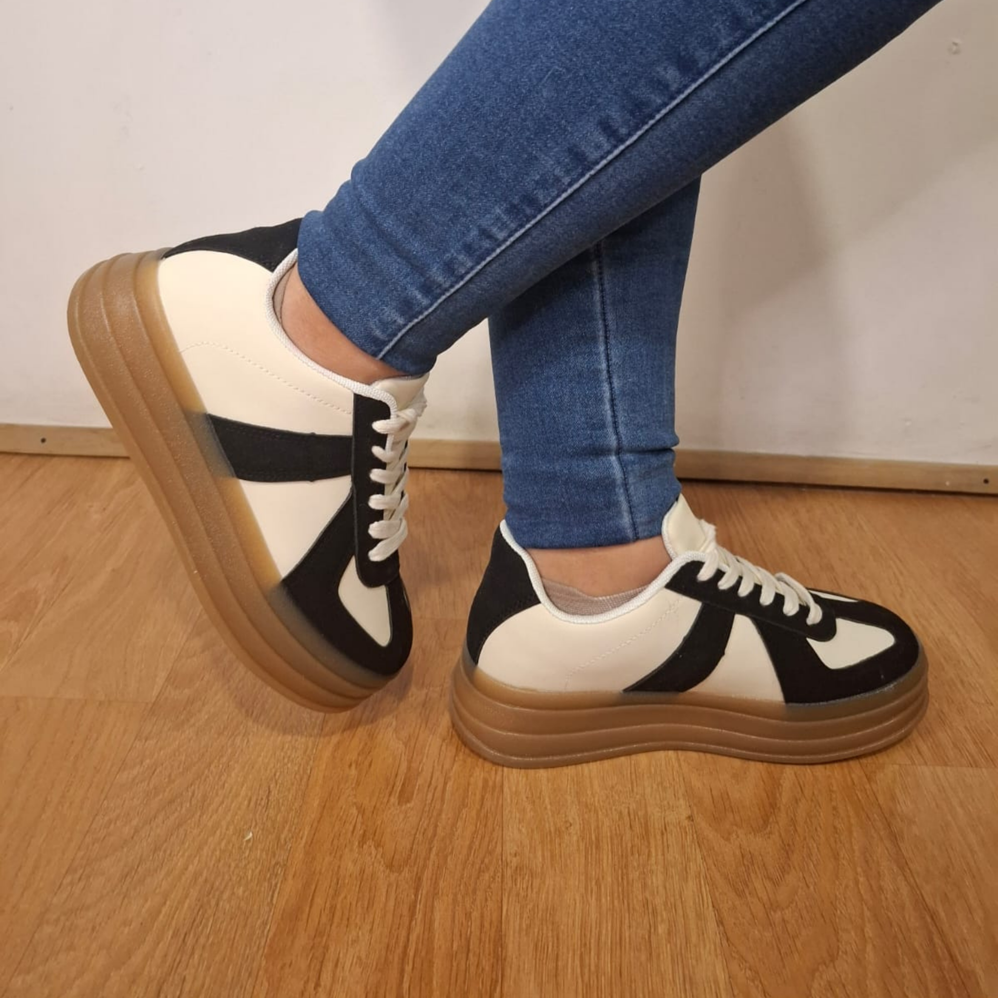 Zapatilla urbana para mujer en color crema con refuerzos y detalles en gamuza negra, cordones blancos y una suela de plataforma ancha en goma color café.vime moda chile